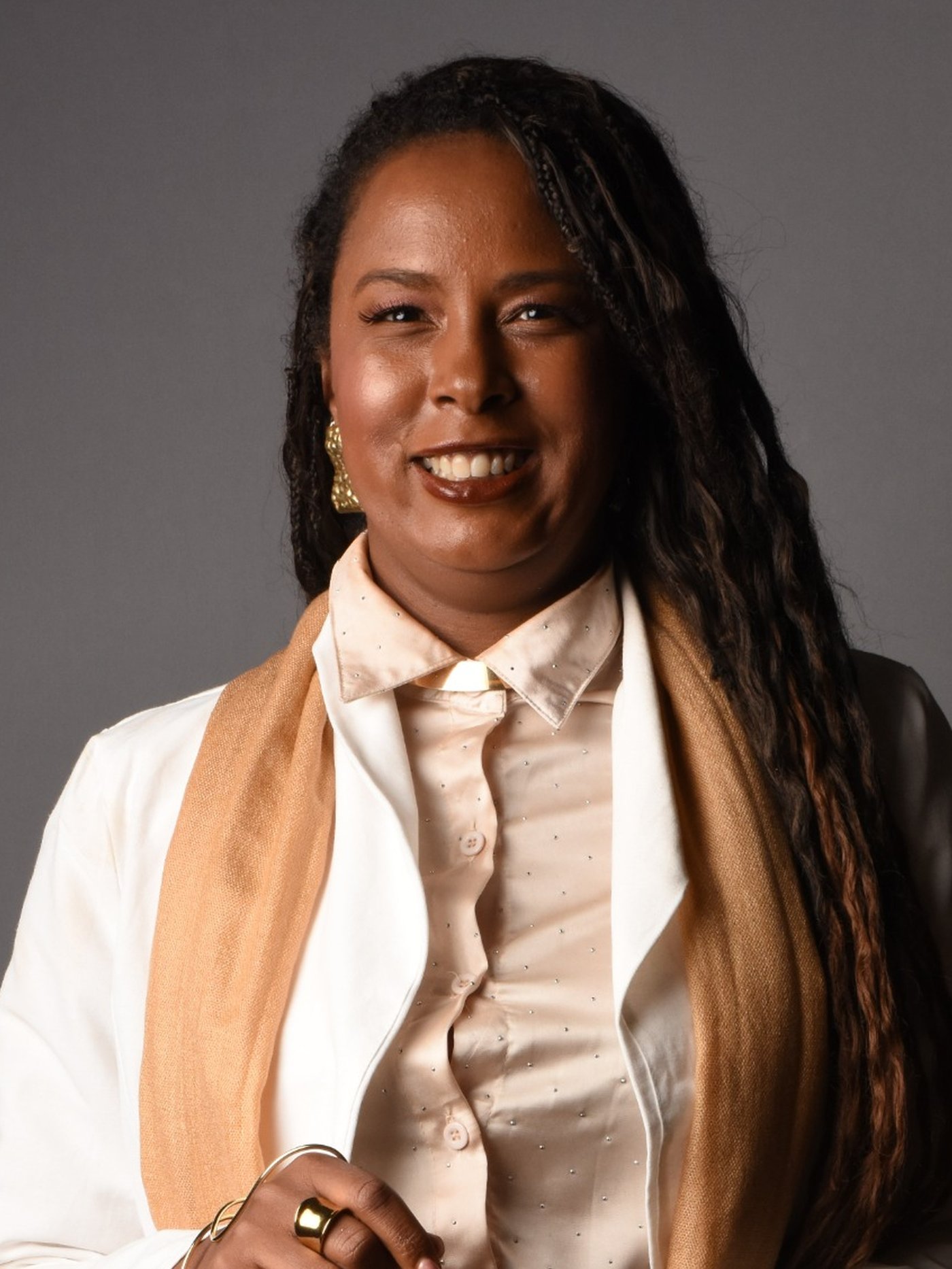Retrato aproximado de Mariza Faria sorrindo, em traje executivo claro.